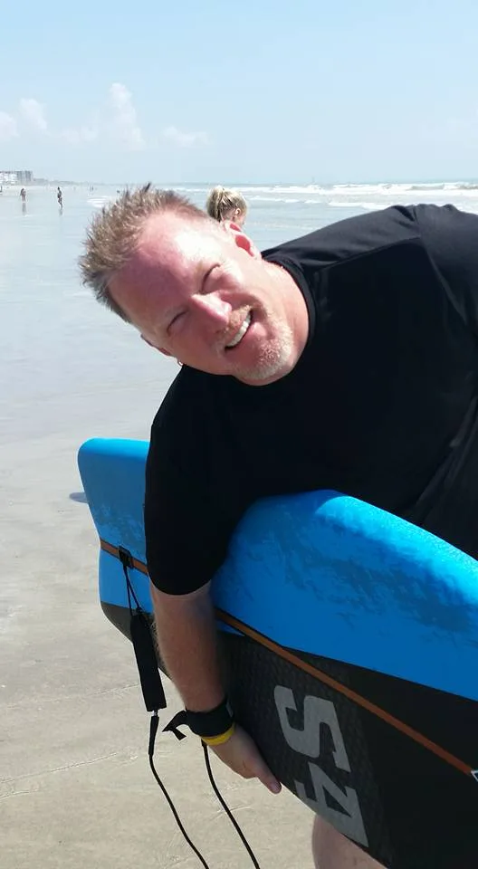 Tony Locke with a bodyboard at the beach